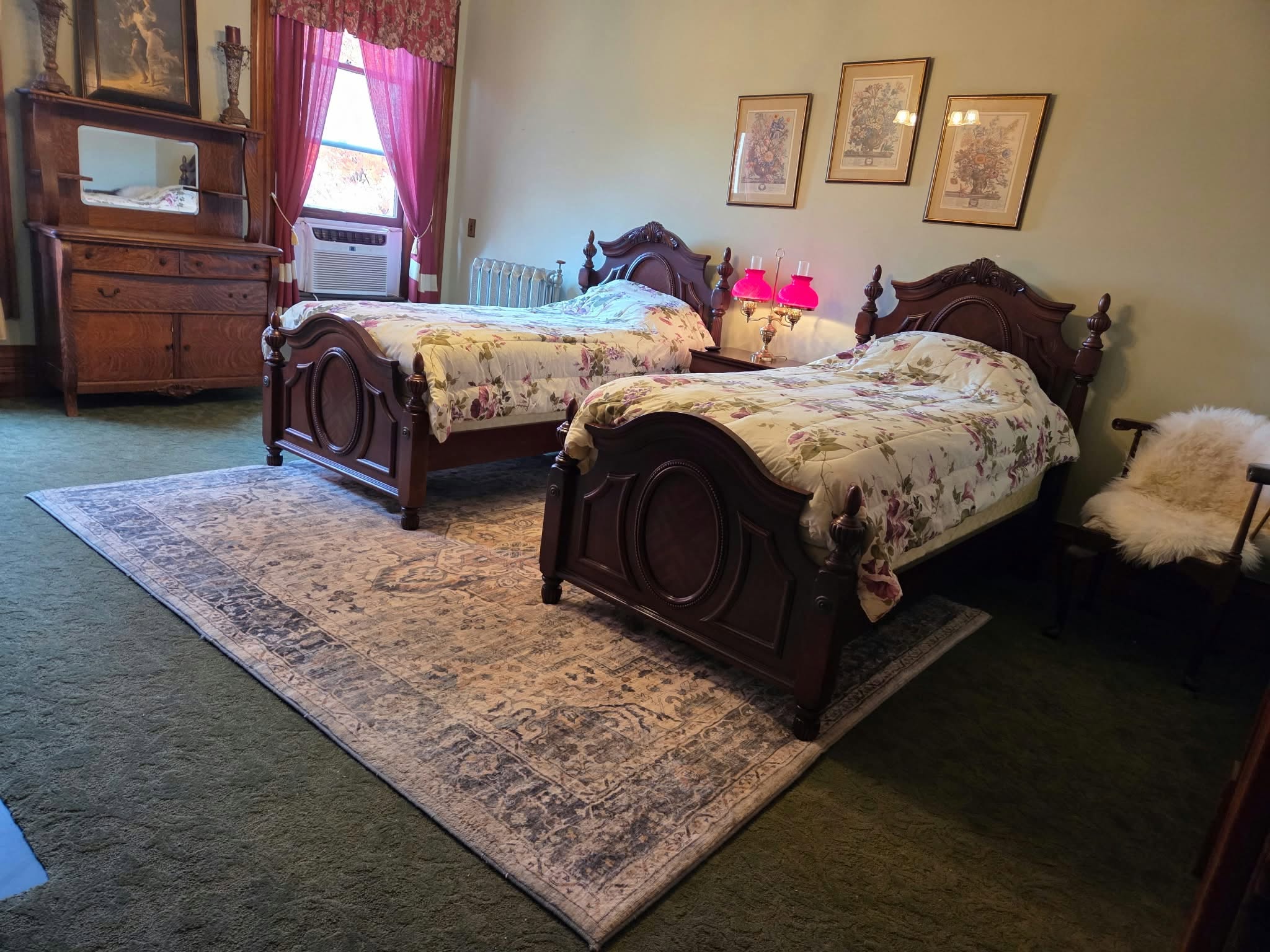 Two beds and antique furnishings in a guest bedroom at the Thomas H. Russell House